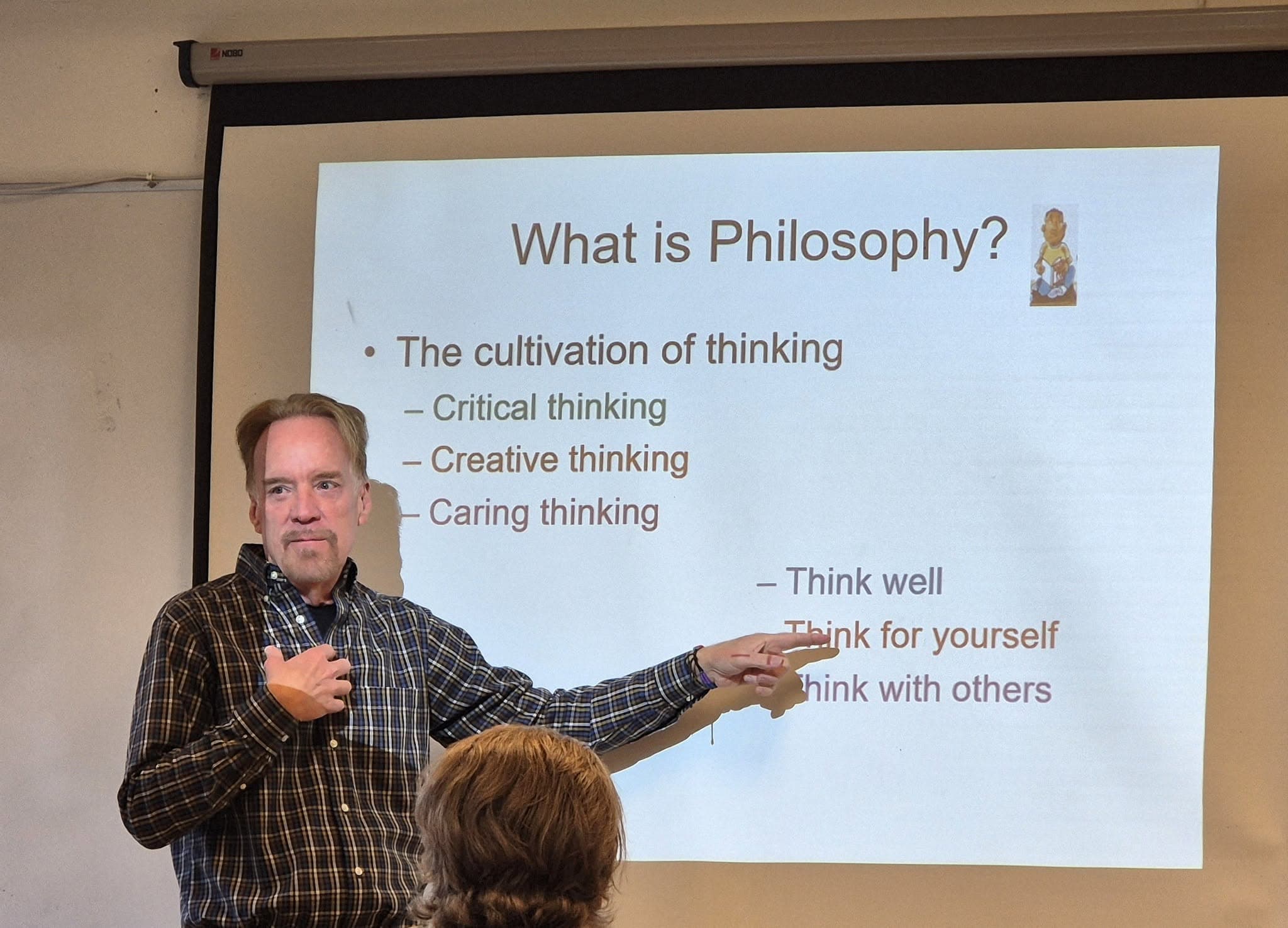 Maughn Gregory pekar på en presentationsbild med rubriken What is Philosophy?