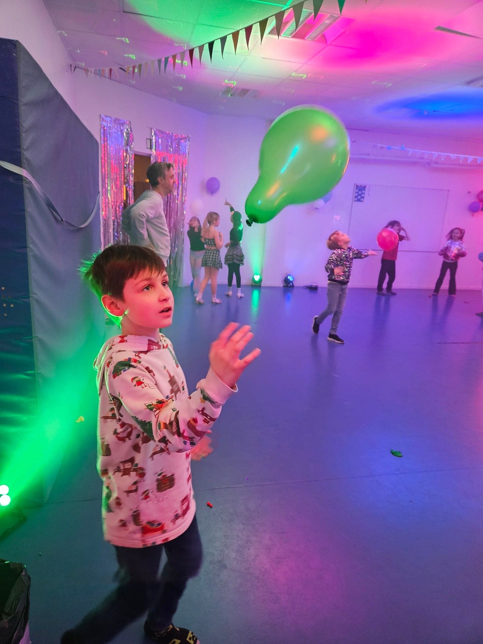 Elev på skoldisco med ballonger och färgade ljus.